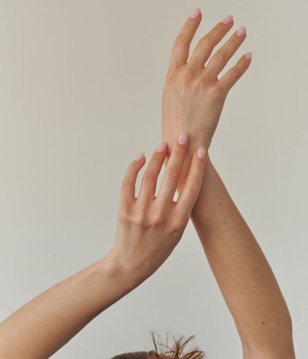 Person in a calm, minimalist space, stretching gently with soft lighting.